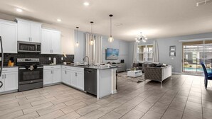 A modern kitchen with white cabinets, stainless steel appliances, and a central island.