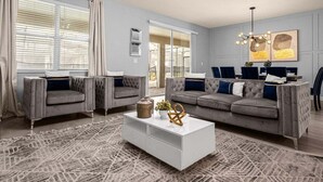 A living room with two grey sofas, a white coffee table, and a patterned rug.