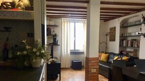 Una sala de estar acogedora con chimenea, comedor y cocina con salpicadero de azulejos.