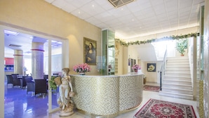 A lobby with a reception desk, a statue, a staircase, and a dining area. - Hotel Madison (Bellaria-Igea Marina)