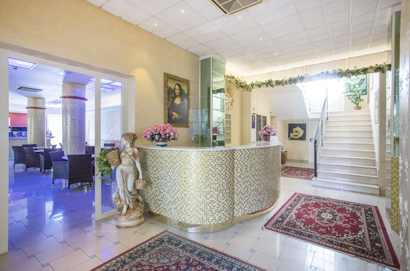 A lobby with a reception desk, a statue, a staircase, and a dining area. - Hotel Madison (Bellaria-Igea Marina)