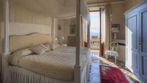 Ein Himmelsbett mit Baldachin, ein Balkon mit Aussicht und ein klassisches Zimmerdesign.
