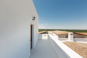 Enjoy breathtaking views from this rooftop terrace with a door and wall-mounted light.