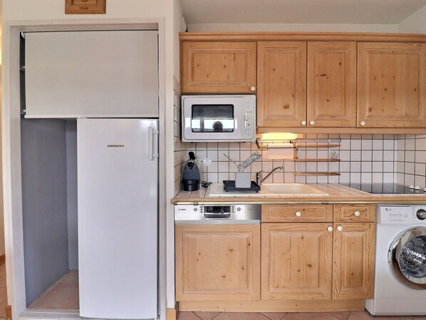Enjoy cooking in this well-equipped kitchen with a refrigerator, microwave, oven, and washing machine.