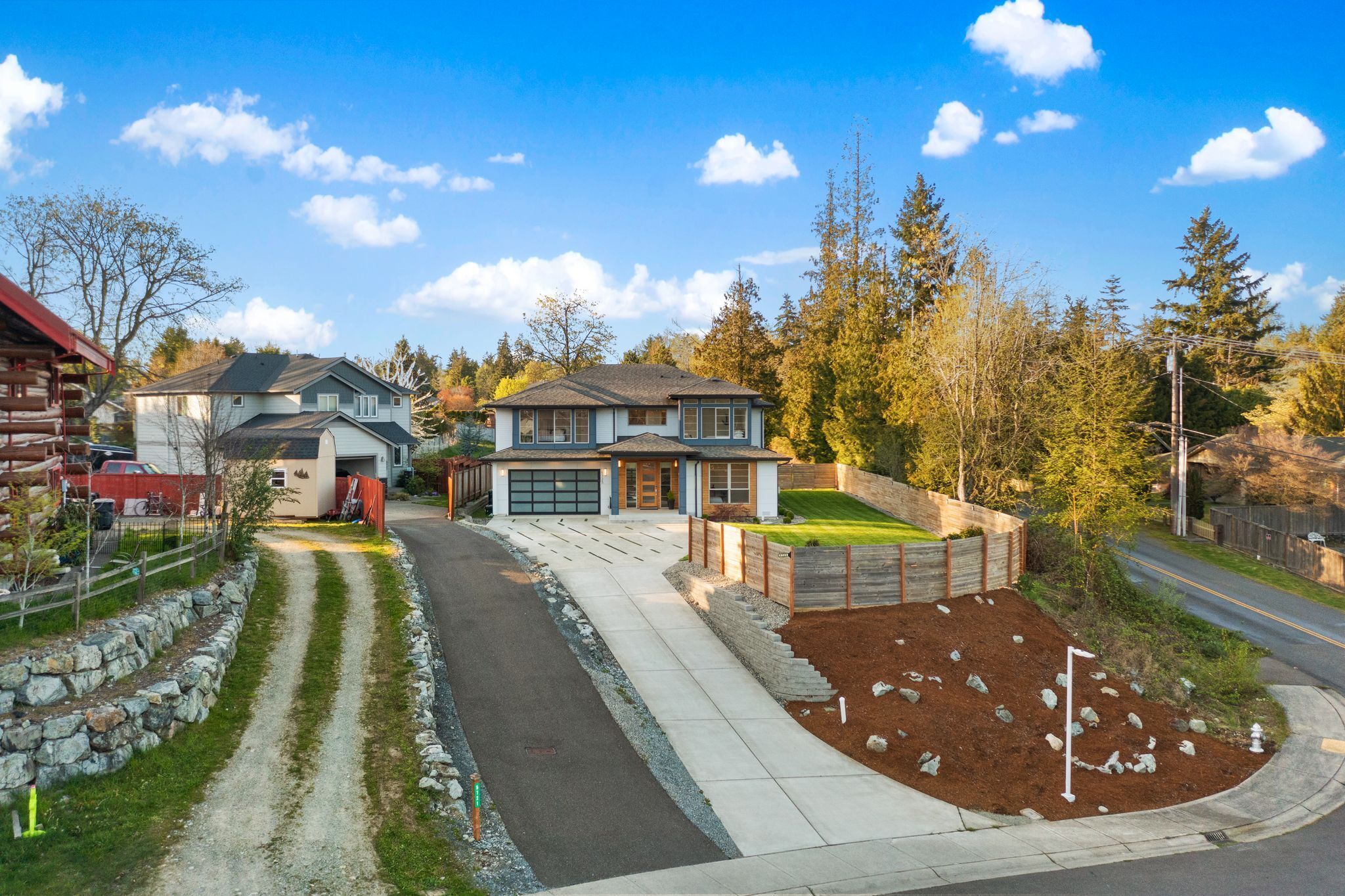 A residential area with houses, a driveway, and a well-maintained lawn.