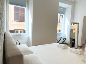 A hotel room with a bed, a large mirror, and a window with shutters. - APARTMENT 3 PANTHEON (Roma)