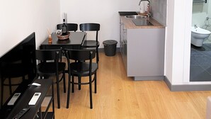 A compact kitchen with a sink, a small dining area with a table and chairs, and a built-in air conditioning unit. - APARTMENT 3 PANTHEON (Roma)