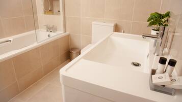 Un baño moderno con una bañera, un lavabo e inodoro.