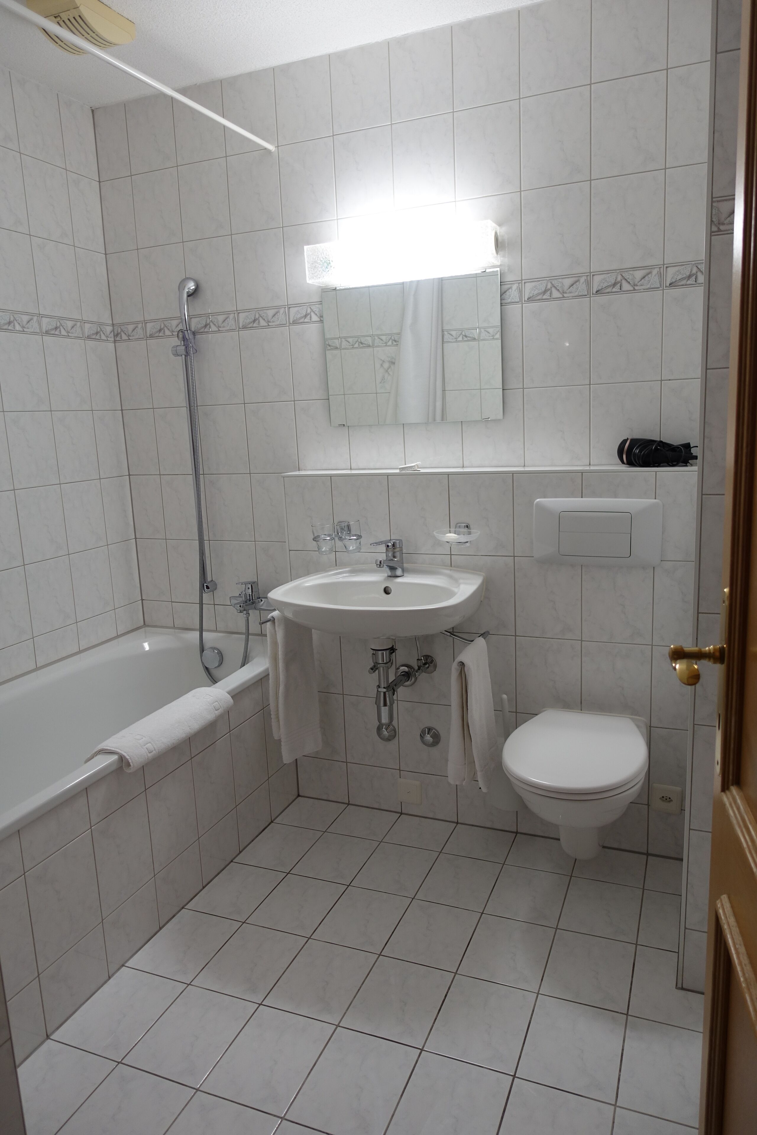 Et badeværelse med badekar, vask og toilet.