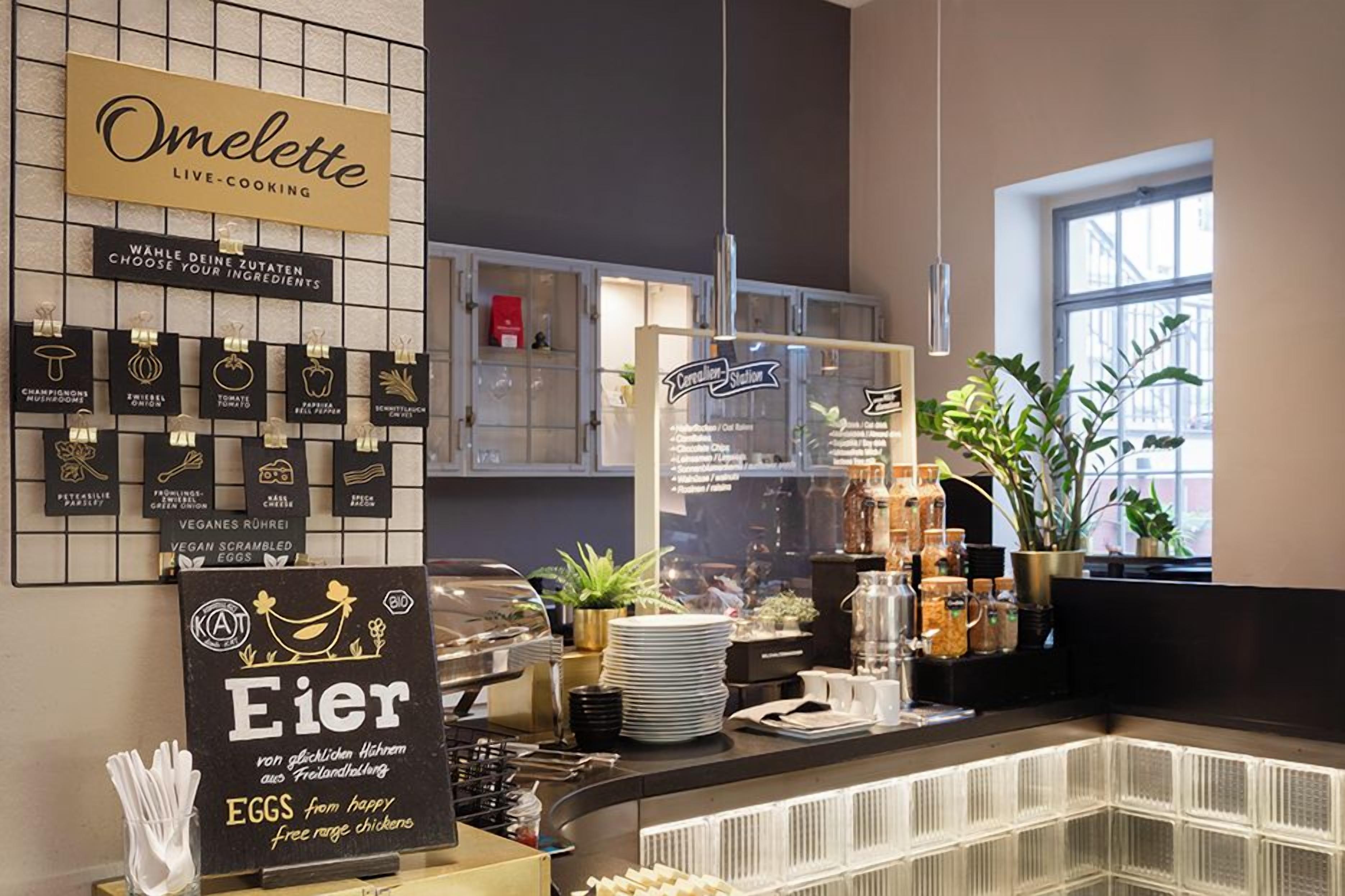 Ein Café mit einem Schild, auf dem 'Omelette Live-Cooking' steht, und einer Speisekarte mit verschiedenen Gerichten.