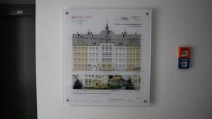 Un dibujo arquitectónico enmarco de un edificio histórico con la etiqueta 'Berlin 1898' sobre una pared.
