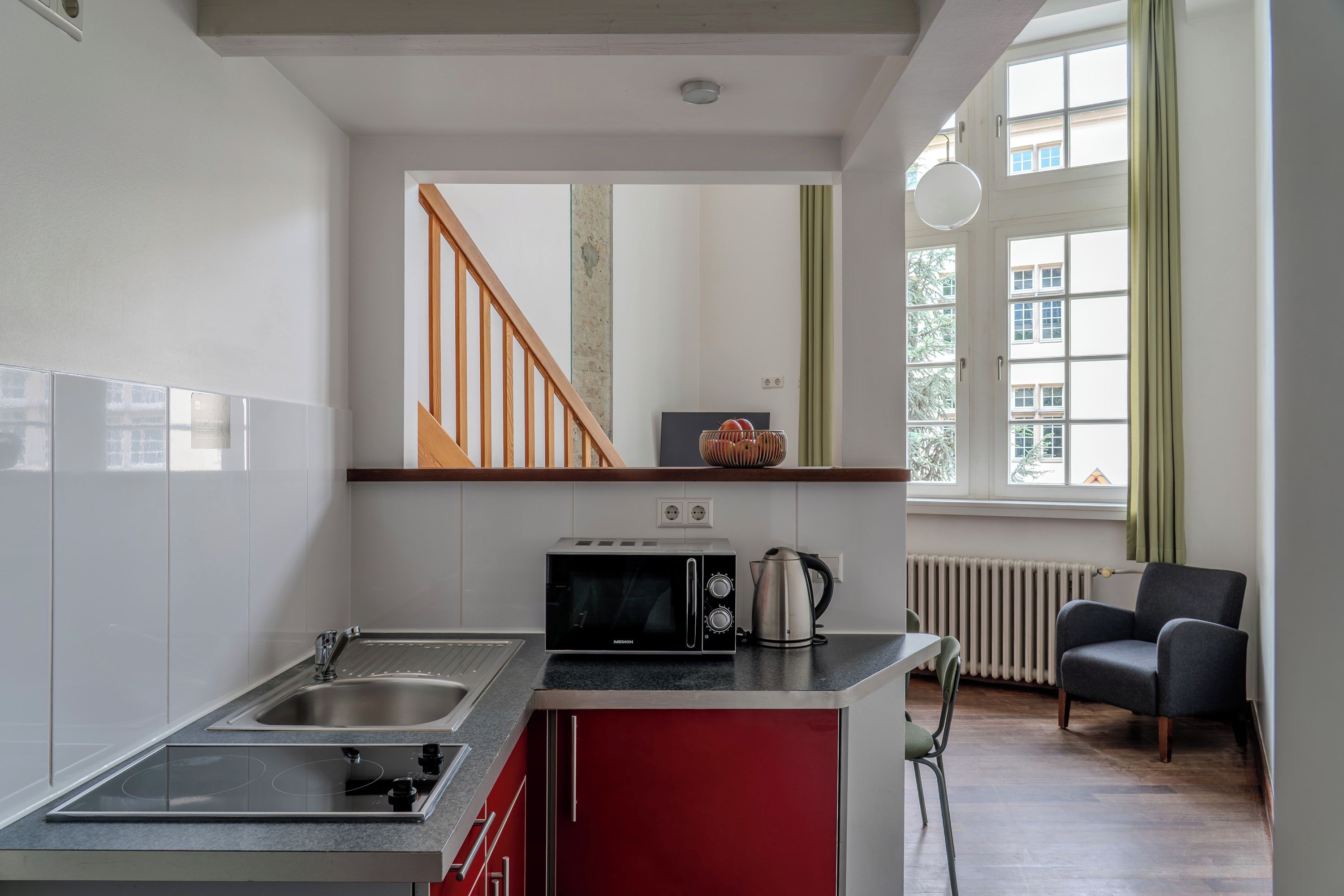 Cocina moderna con microondas integrado, hervidor y pileta de acero inoxidable.