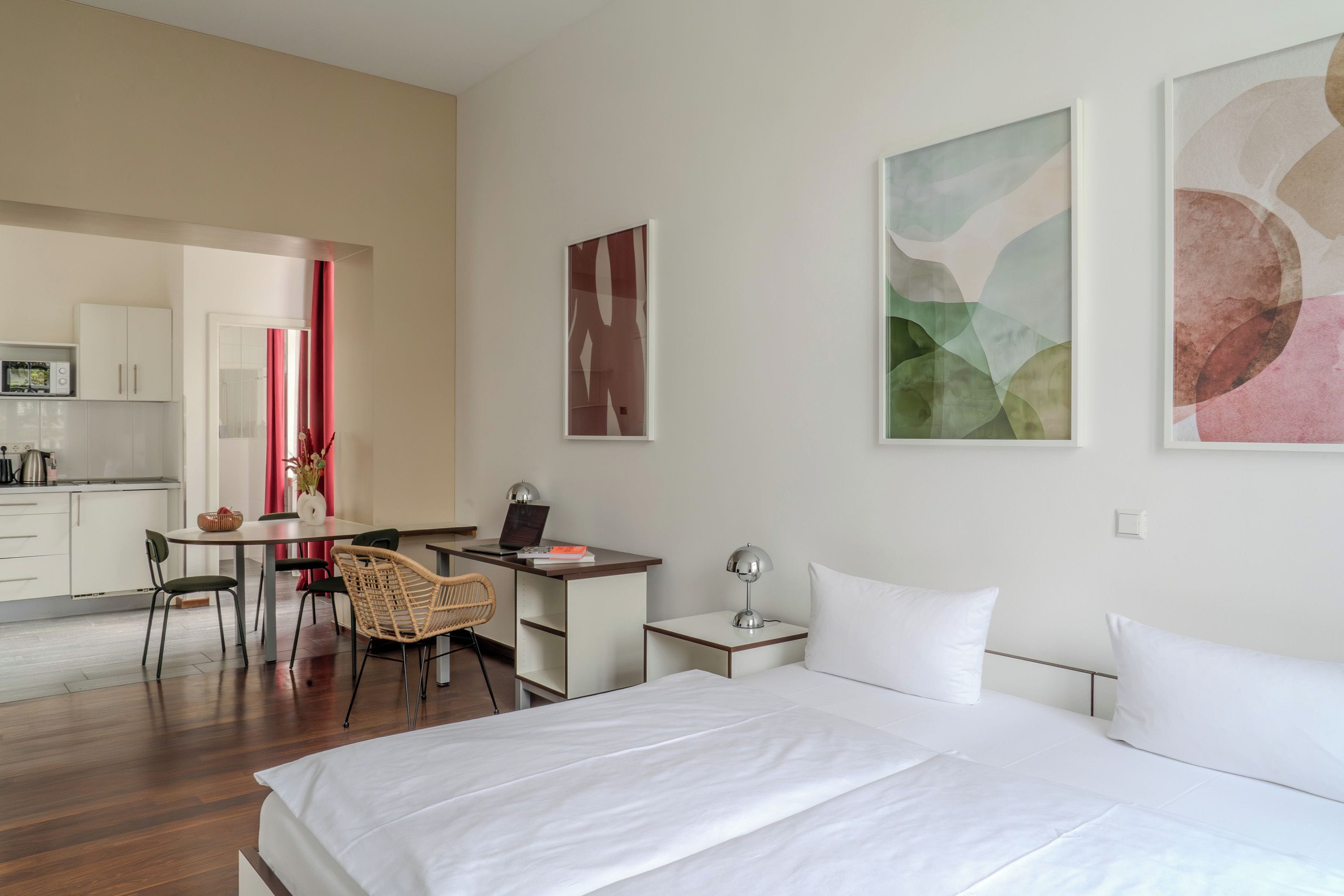 Une chambre d’hôtel équipée d’un lit, d’un bureau, d’une chaise et offrant une vue sur la cuisine.