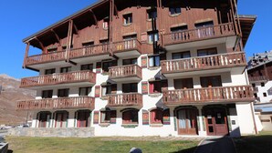 Un edificio de varios pisos con balcones y arquitectura de madera tradicional.