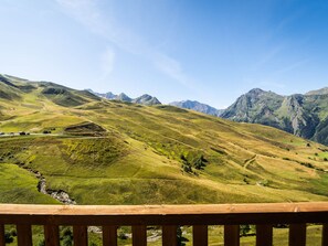 A panoramic view of a mountainous landscape with a wooden railing in the foreground. - Charming Ski-in/Ski-out Apt with Balcony, Sleeps 6, Access to Spassio Spa, Close to Amenities (Peyragudes)