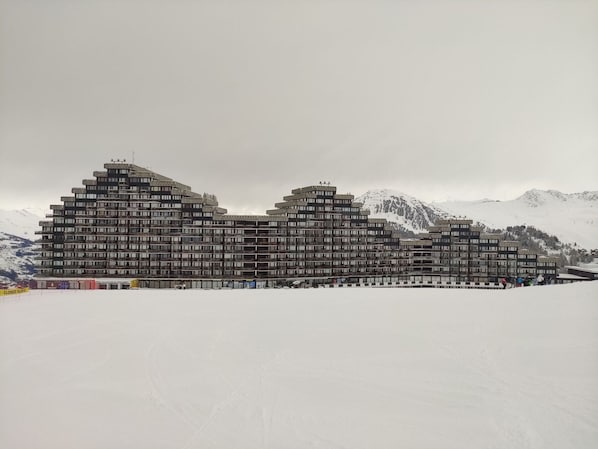 A multi-story hotel with a modern architectural design, featuring balconies and a flat roof.