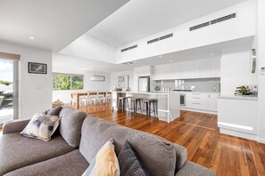 A modern kitchen with white cabinetry, a central island, and bar stools.