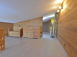 Ein Zimmer mit Holzwänden und einem großen Holzschrank mit mehreren Schubladen.