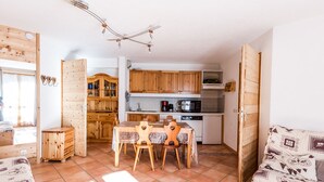 Un espace de vie compact comprenant un coin cuisine, des meubles en bois et une table à manger.