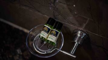 Two bottles of Grand Lotus shampoo on a marble surface.