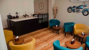 A modern lounge area with a bar, teal and yellow chairs, and a decorative motorcycle on the wall. - Grand Lotus Dimapur (Dimapur)