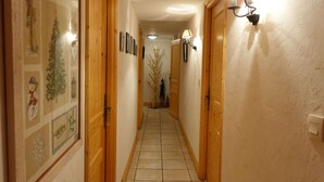 A narrow hallway with wooden doors and tiled flooring. - Chalet for 14 with terrace in the heart of Arêches-Beaufort (Arêches-Beaufort)