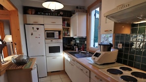 A compact kitchen with a refrigerator, oven, microwave, and a stove. - Chalet for 14 with terrace in the heart of Ar êches-Beaufort (Arêches-Beaufort)
