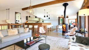Una sala moderna con un sofá, sillones, una mesa de centro y una chimenea.