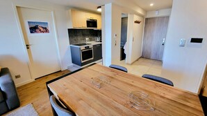 Une cuisine moderne avec des carreaux de couleur sombre, un four encastré et un four à micro-ondes.
