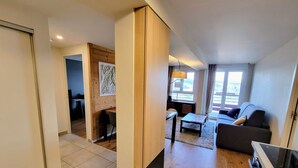 Un salon moderne comprenant un canapé, une table à manger et un coin cuisine avec une cuisinière.