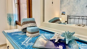A bathroom with a blue patterned mat, a mirror, and a decorative starfish on a tray. - Villa with private pool, 10 minutes from the sea, large garden*parking*BBQ  (Sardegna)