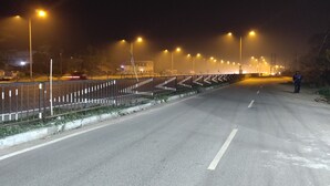 A nighttime street scene with a road, streetlights, and a person standing by the roadside. - Hotel OPS (Kolkata)