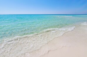 A beach with clear turquoise water and white sand.