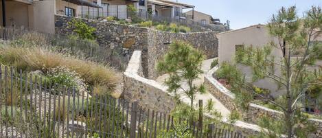 A residential area with houses, stone walls, and a wooden fence.