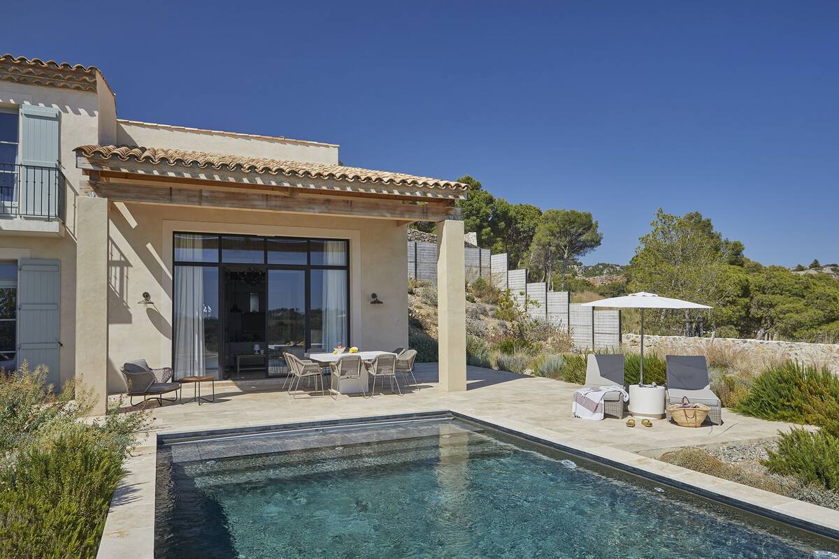 A modern house with a swimming pool, outdoor seating, and a pergola.