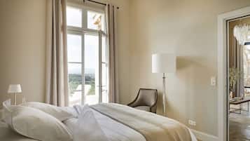 A hotel room with a large bed, a chair, a floor lamp, and a view of the outdoors.