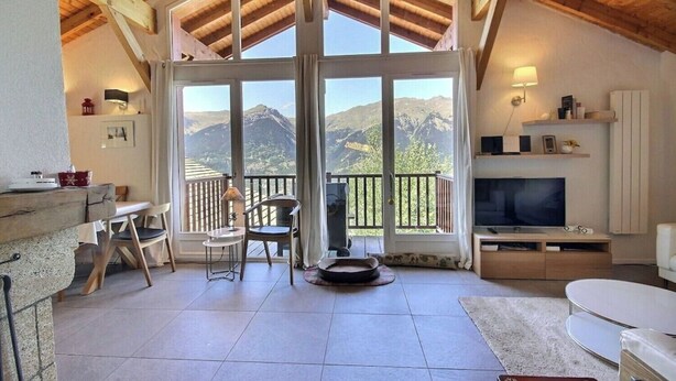 A cozy room with a wooden ceiling, large windows offering mountain views, a TV, and a fireplace. - Chalet La Plagne Tarentaise (LA PLAGNE MONTALBERT)