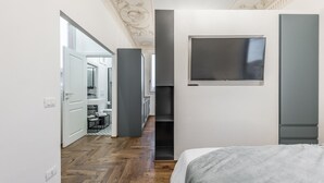 A modern bedroom with a large bed, a TV mounted on the wall, and a wardrobe. - L'Altana di Emilia Suite (Modena)