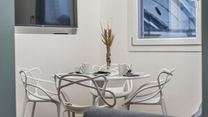 A white table with four chairs, a vase with dried plants, and two white cups on the table. - L'Altana di Emilia Suite (Modena)
