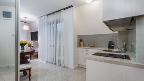 Una cocina moderna con estufa integrada, un fregadero y un comedor con mesa y sillas.