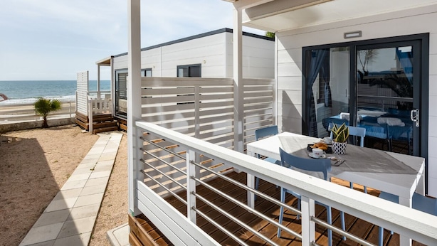 A modern beachside villa with a covered patio, a dining area, and a view of the sea. - Anxur Village Camping (Fondi)