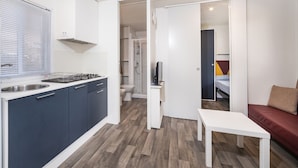 A compact living space with a kitchenette, a small bathroom, and a seating area. - Anxur Village Camping (Fondi)