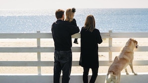 A family of three and a dog on a beach boardwalk with a view of the ocean. - Anxur Village Camping (Fondi)