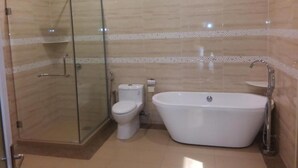 A modern bathroom with a glass-enclosed shower, a toilet, and a freestanding bathtub. - Capital O 90653 Maxwell Inn Boutique Hotel (Taiping)