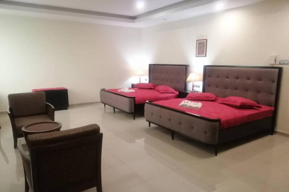 Une chambre d’hôtel avec deux lits, une chaise et une petite table.
