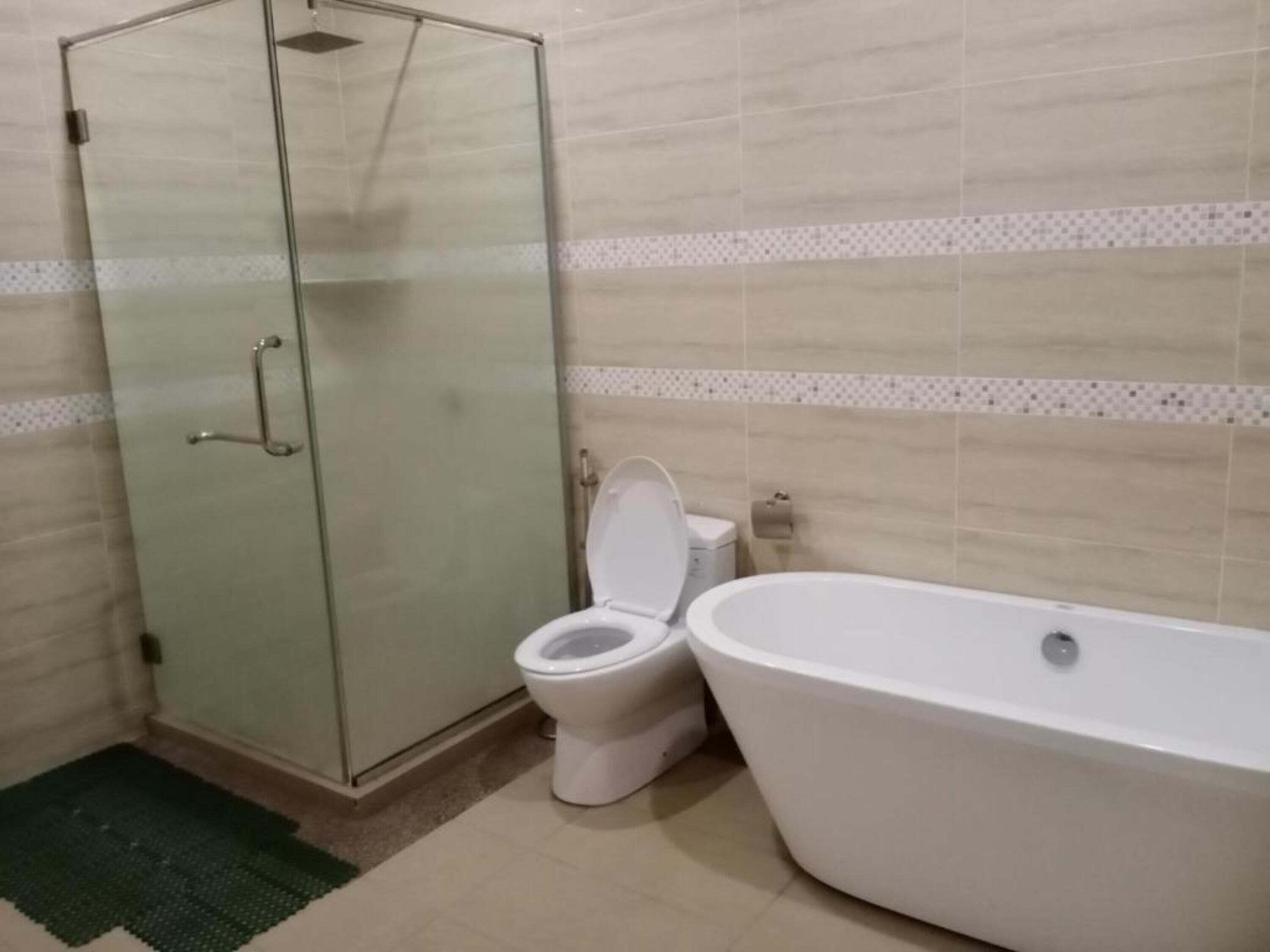 A bathroom with a glass-enclosed shower, a toilet, and a freestanding bathtub.