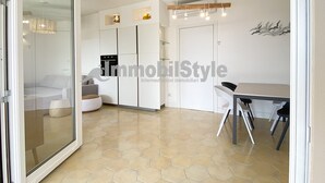 Cozinha moderna com armários brancos, uma mesa de jantar e cadeiras.