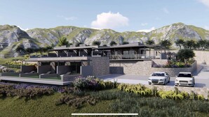 Une maison moderne à deux étages, dotée d’une piscine, entourée d’un jardin aménagé et offrant une vue sur un paysage montagneux.