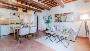 A spacious living area with a dining table, chairs, a sofa, and a coffee table.