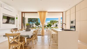 Una cocina moderna con comedor, ventanas amplias y vistas al exterior.